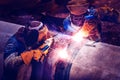 Workers with protective masks welding bore pile metal casing at a construction site. Royalty Free Stock Photo