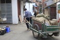 Workers pull wooden handcart