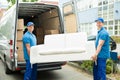 Workers Putting Furniture And Boxes In Truck Royalty Free Stock Photo