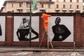 Workers are putting up posters showcasing the Moncler collection of 2023 on the walls, Milan