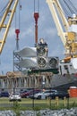 Workers readying wind turbine blades for unloading from ship