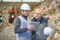 workers recycling company looking at tablet