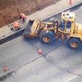 Workers remove the asphalt by putting it in the bucket of the excavator - Moscow, Russia, may 18, 2020