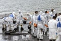 Workers remove and clean up crude oil spilled from Prao Bay