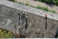 workers remove slate from the roof of a building