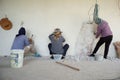 Workers removing the plastered cement surface on the bricklayer