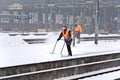 Workers removing snow from the station platform