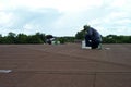 Closeup the solar cell on the roof with motion blurred worker fixing and sealing the surface