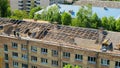 Workers repair and replace roofing on an old red brick building. Spring construction work. Repair and maintenance of city Royalty Free Stock Photo