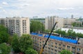 Workers repair and replace roofing on an old red brick building. Spring construction work. Repair and maintenance of city Royalty Free Stock Photo