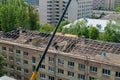 Workers repair and replace roofing on an old red brick building. Spring construction work. Repair and maintenance of city Royalty Free Stock Photo