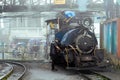 Workers repairing the small steam engine of the toy train on a foggy morning a popular tourist destination