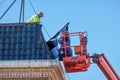 Workers replacing roofing tiles