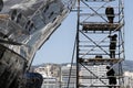 Workers repairing a boat in a scaffold.