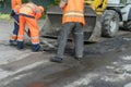 Workers on a road construction, industry and teamwork. builders workers at asphalting paver machine during Road street