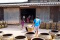 Workers rolling lots of Dragon design pots and flower pots from stove.