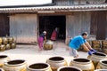 Workers rolling lots of Dragon design pots and flower pots from stove.
