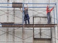The workers on the scaffolding. Workers on construction sites. Russia. Saint-Petersburg. Summer 2017.