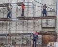 The workers on the scaffolding. Workers on construction sites. Russia. Saint-Petersburg. Summer 2017.