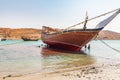 Workers scraping the bottom paint off a dhow in the harbor at Sur, Oman Royalty Free Stock Photo