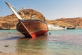 Workers scraping the bottom paint off a dhow in the harbor at Sur, Oman Royalty Free Stock Photo