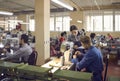 Workers at a shoe factory making new footwear details on industrial sewing machines