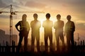 Workers silhouette against construction site backdrop in photo Royalty Free Stock Photo