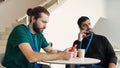 Workers sit at lunch in office cafe. Media. Two workers with badges are sitting at table. Office workers relax on their Royalty Free Stock Photo