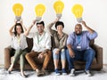 Workers sitting and holding lightbulb icons Royalty Free Stock Photo