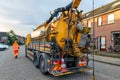 Workers with specialized truck cleaning sewer system in residential area