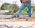 Workers spreading concrete over the slab