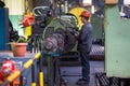 Workers stand behind the machines at the factory and work.