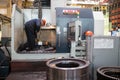 Workers stand behind the machines at the factory and work.