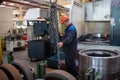 Workers stand behind the machines at the factory and work.