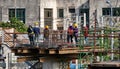 Workers stand on a steel platform on a construction site