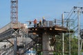 Workers stand on a steel platform on a construction site