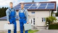 Workers Standing In Front Of House With Solar Panels Royalty Free Stock Photo