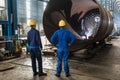 Workers supervising the manufacture of a metallic cylinder Royalty Free Stock Photo