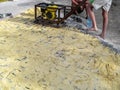 Workers tamping a new laid paving slab with a self-production vibrating plate. The process of installing granite cobblestones on