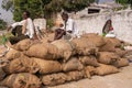 Workers on top of stack of rice bags, Ayodhya, Karnataka, India