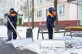 Workers in uniform with big shovels. Snow removal on the city streets Royalty Free Stock Photo