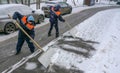 Workers in uniform with big shovels. Snow removal on the city streets Royalty Free Stock Photo