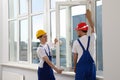 Workers in uniform installing plastic window indoors Royalty Free Stock Photo
