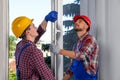 Workers in uniform installing plastic window indoors Royalty Free Stock Photo