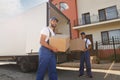 Workers unloading boxes from van outdoors. Moving service Royalty Free Stock Photo