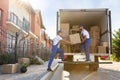 Workers unloading boxes from van. Moving service Royalty Free Stock Photo