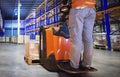 Workers Unloading Package Boxes on Pallets in Storage Warehouse. Electric Forklift Pallet Jack Loader. Warehouse Logistics Royalty Free Stock Photo