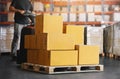 Workers Unloading Package Boxes on Pallets in Warehouse. Electric Forklift Pallet Jack Loader. Royalty Free Stock Photo