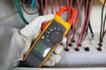 Workers use clamp meter to measure the current of electrical wires produced from solar energy for confirm to normal current Royalty Free Stock Photo