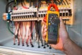 Workers use clamp meter to measure the current of electrical wires produced from solar energy for confirm to normal current